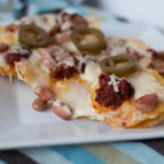 Simple Chorizo Nachos are just what your weekend needs. Spiced pinto beans, flavorful chorizo, melted cheese and spicy jalapenos all atop crispy tortilla chips.