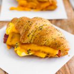 These Baked Breakfast Croissant Sandwiches start with a buttery, flaky croissants and are filled with scrambled eggs, crisp bacon and melted cheddar cheese to create a delicious hand held breakfast to enjoy at home or on the go.