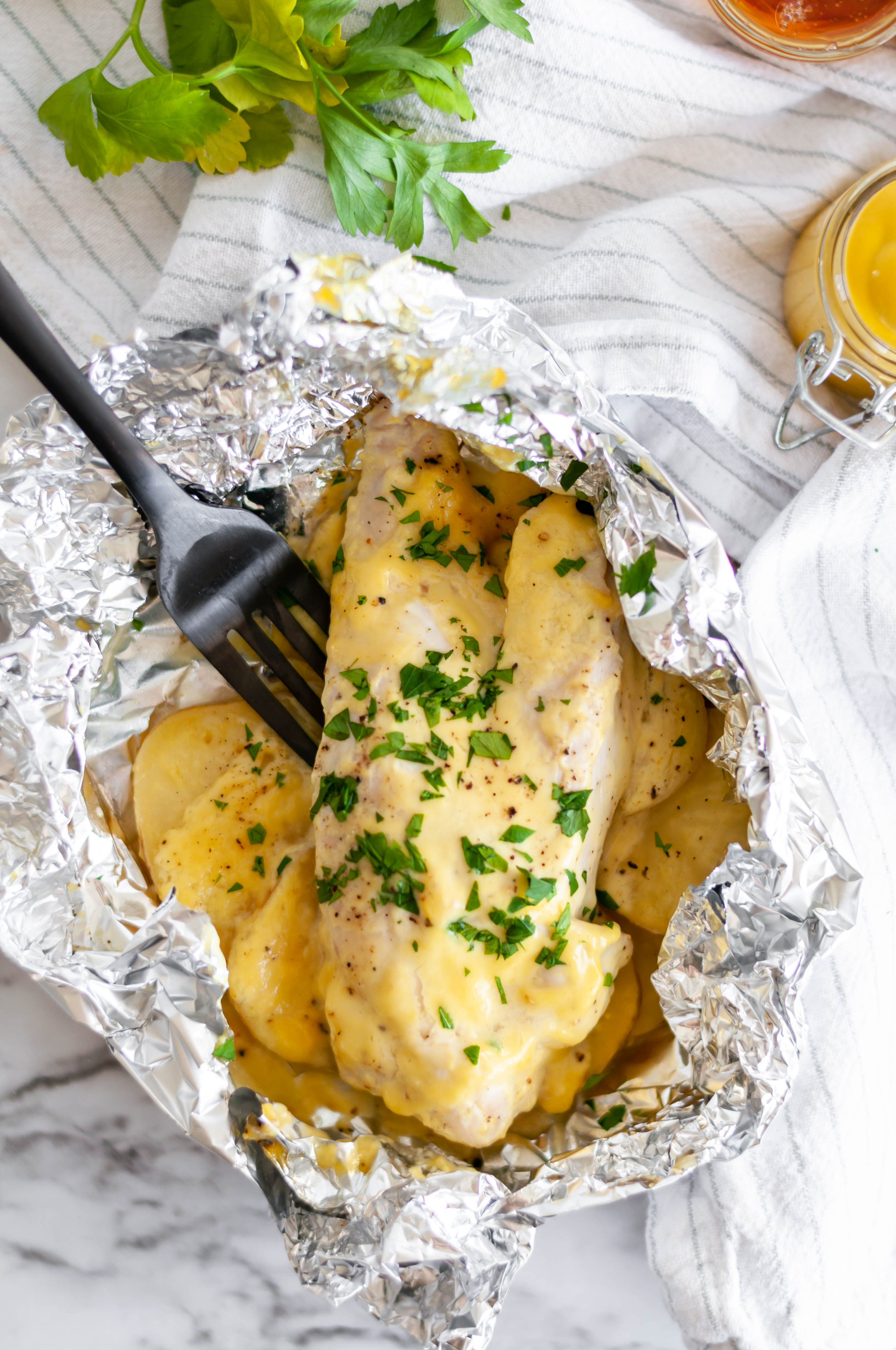 Honey Mustard Chicken and Potato Foil Packs are a simple weeknight dinner the whole family will love. Chicken breasts, thinly sliced potatoes and a simple homemade honey mustard sauce.