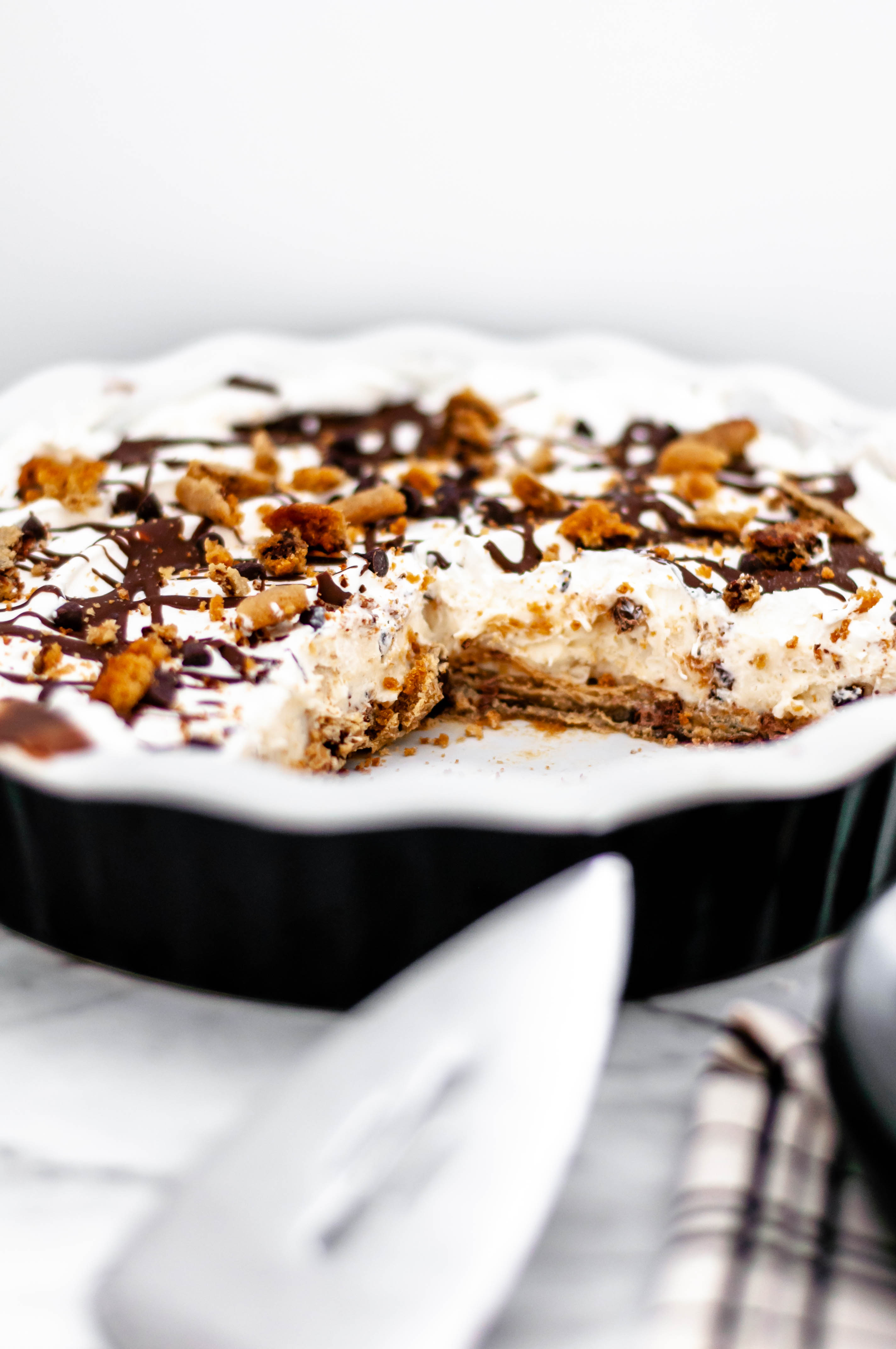 Chocolate Chip Cookie Dough Ice Cream Pie is the ultimate dessert. Cookie dough crust, cookie dough ice cream, whipped cream and chocolate syrup.