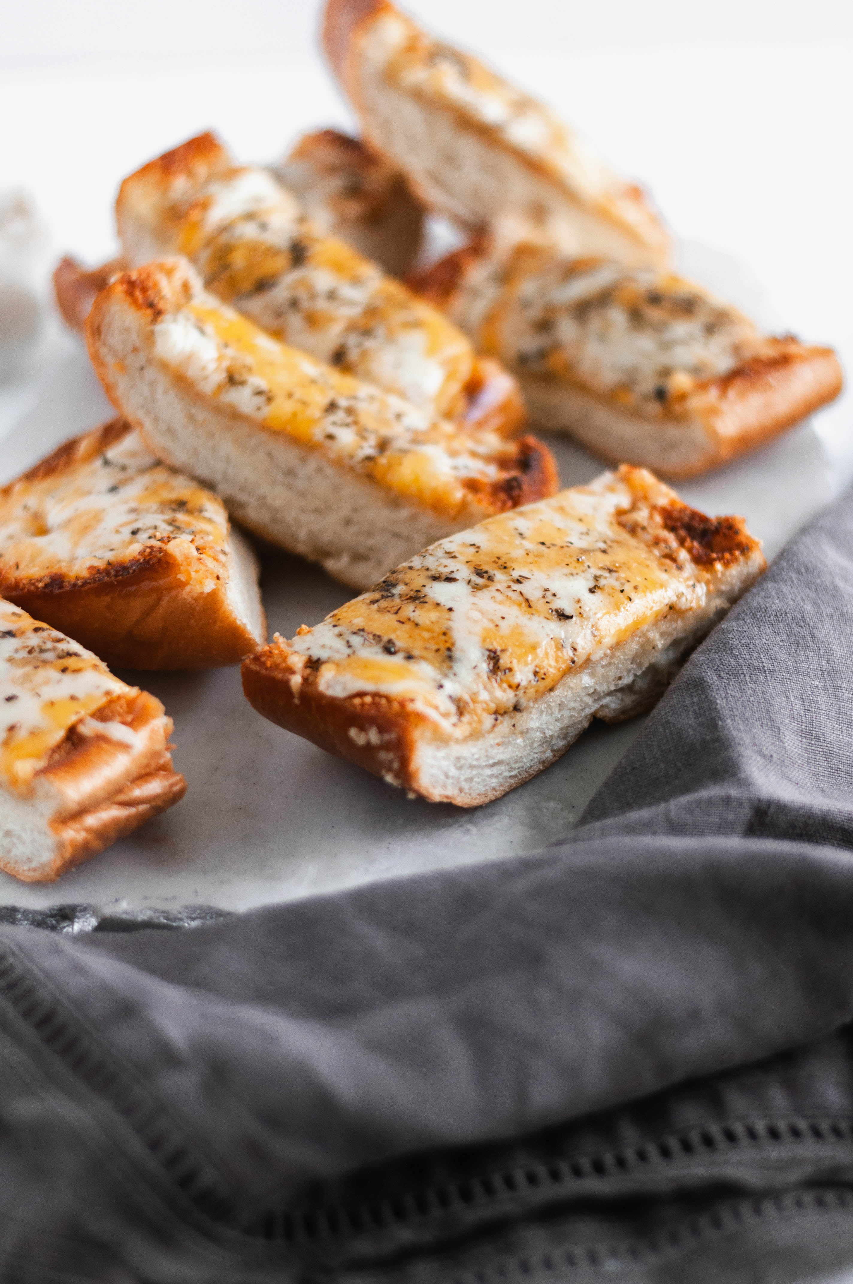 This Ultimate Cheesy Garlic Bread is the perfect addition to dinner tonight. Buttery garlic bread smothered in three cheeses and Italian seasoning.