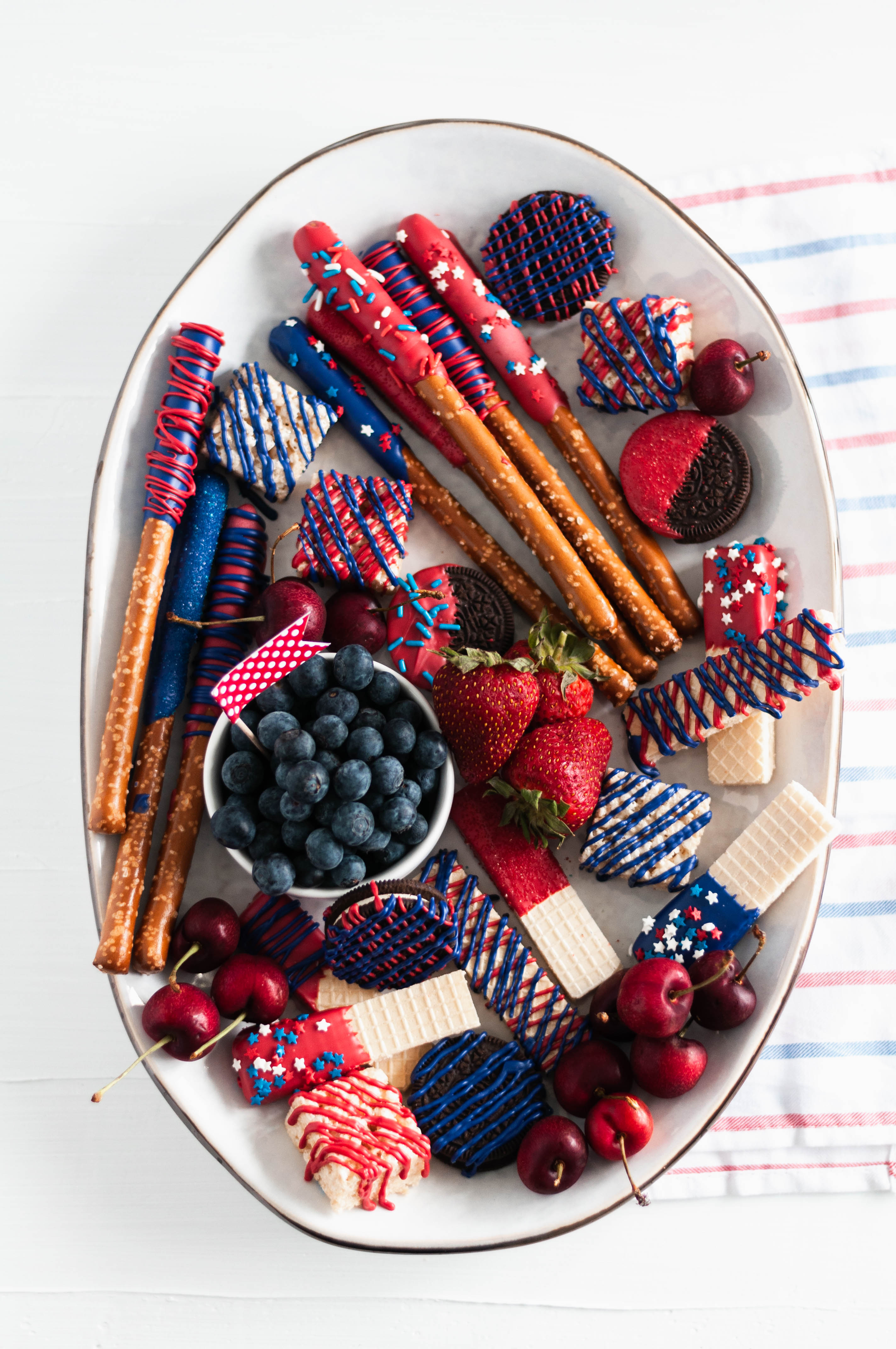 You'll be the hit of the 4th of July party when you show up with this Red White and Blue Dessert Board. Super simple to make with store-bought ingredients, some time and all your creative juices.