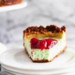 This PIstachio Cheesecake is a delightful holiday dessert. Thick, creamy cheesecake studded with pistachio flavor throughout the filling and crust. Top with cherries to make it extra festive.