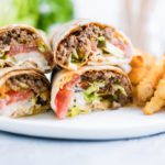A fun twist on the classic cheeseburger, these Cheeseburger Wraps feature ground beef, cheese, burger sauce, lettuce, tomato and pickles all wrapped up in a flour tortilla.