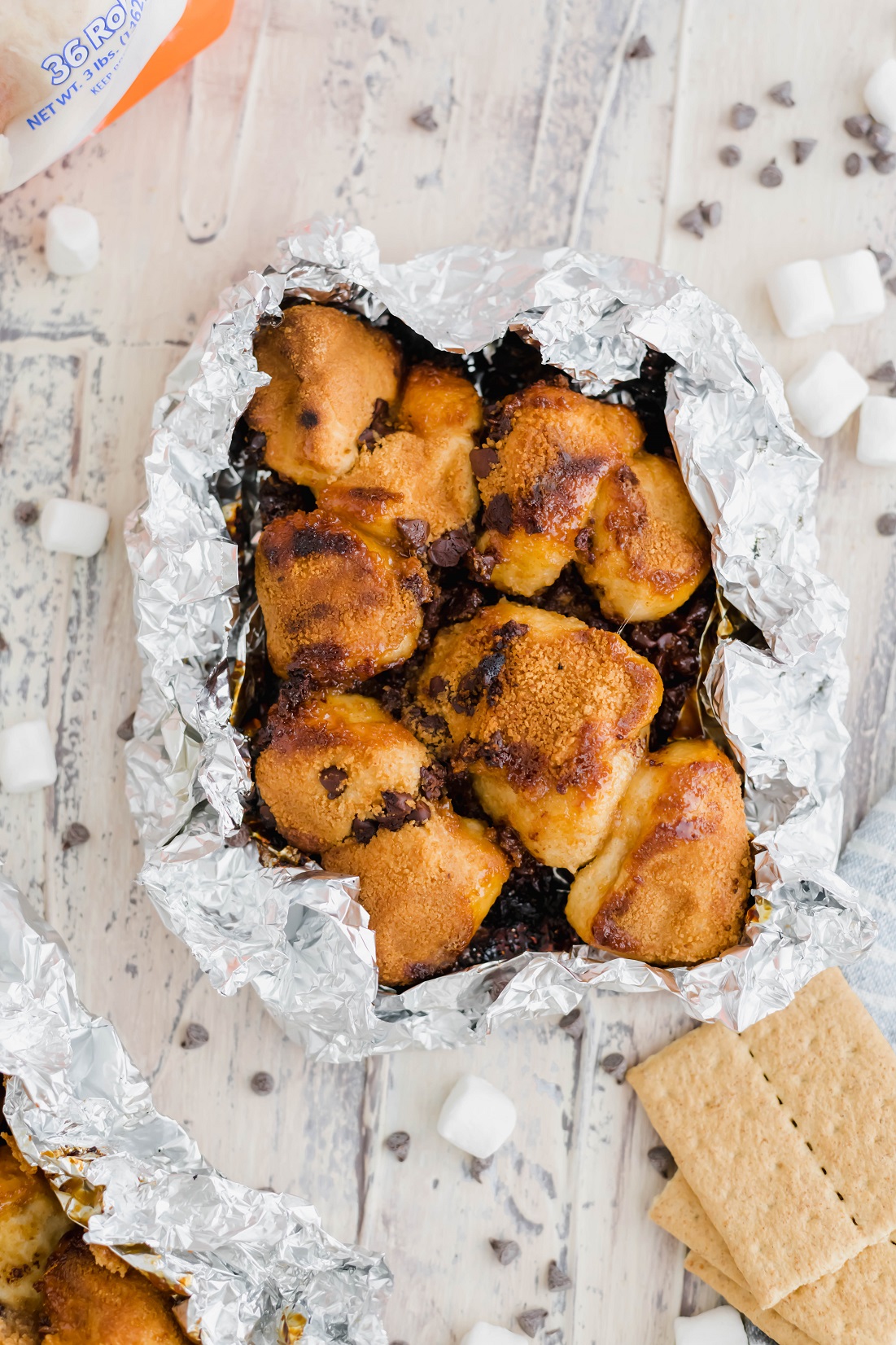 Summertime is upon us and this summer, we’re firing up the grill for a super fun dessert featuring Rhodes Bake-N-Serv rolls. This Campfire S’mores Monkey Bread is super simple to make on the grill or in the oven for a fun spin on a summertime classic.