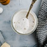 Parmesan peppercorn dressing in a wide mouth mason jar. Spoon in the jar slightly lifting a spoonful.