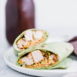 BBQ Chicken Wrap sliced on the diagonal on a white plate with blue corn toritlla chips.