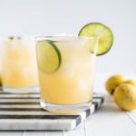 Two guava margaritas on a black and white striped hexagon marble board.