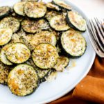 White plate filled with baked parmesan zucchini bites.