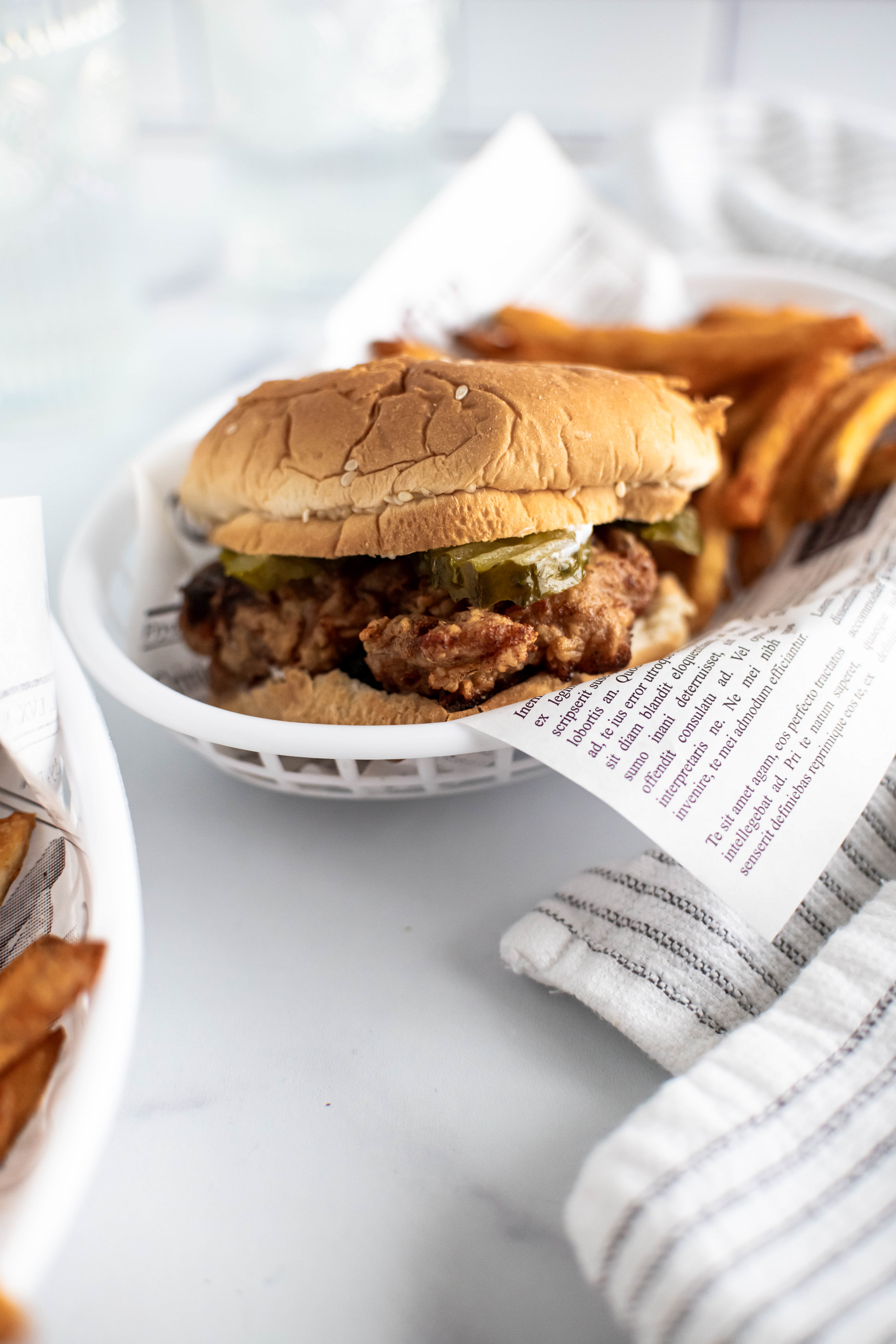 Fried chicken sandwich in a basket with fries.