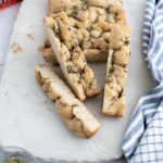 Mini focaccia on a marble board cut with a few slices arranged around.