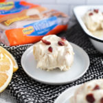 Orange Cranberry Roll on a round white plate with Rhodes bread dough package in the background.